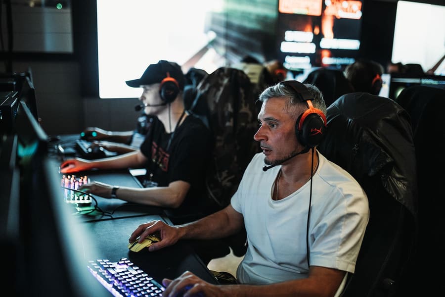 A player in a headset concentrating at his PC at the Masters 2023 LAN